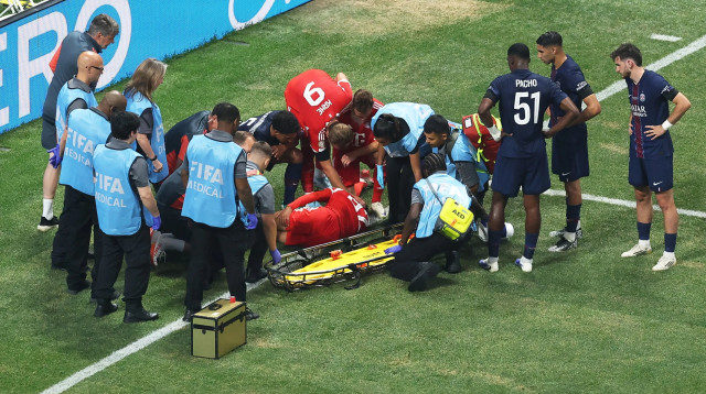 ג'מאל מוסיאלה שחקן באיירן מינכן מקבל טיפול, מסביבו שחקני פריז סן ז'רמן (צילום: רויטרס)