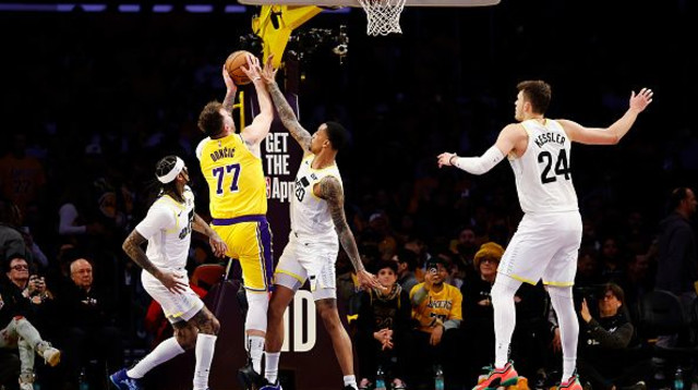 לוקה דונצ'יץ' עולה לסל מול ג'ון קולינס (צילום: Getty images)