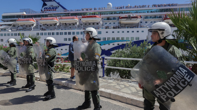 שוטרים יוונים מאבטחים ספינת "מנו ספנות" (צילום:  COSTAS METAXAKIS/AFP via Getty Images)