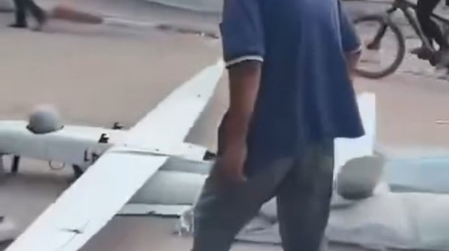 פלסטינים מפנים כטמ"מ של צה"ל שצנח בעזה (צילום: צילום מסך רשתות ערביות)