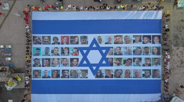 06:29 דגל ישראל עם תמונות החטופים והחטופה בכיכר החטופים (צילום: יאיר פלטי)