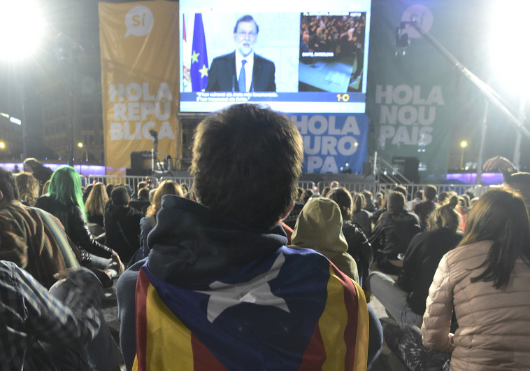 קטלונים ברחובות ברצלונה צופים בנאום רחוי. צילום: AFP