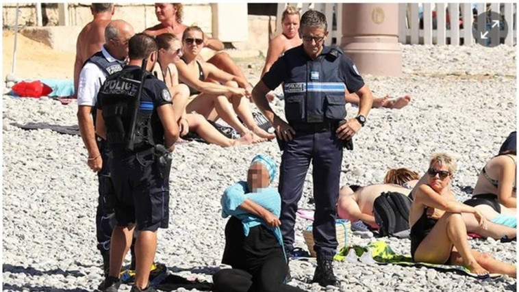 מוסלמית נדרשת לפשוט בורקיני, חוף הים בצרפת. צילום מסך מתוך אתר ה'גארדיאן'