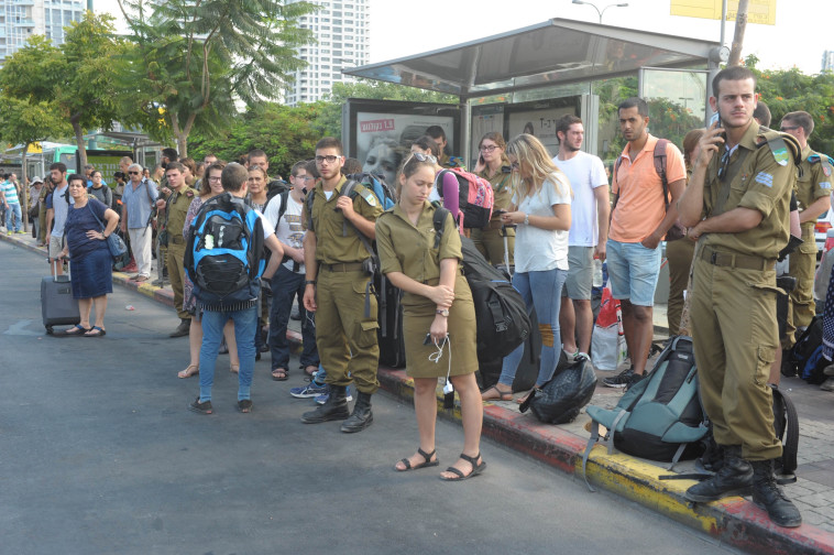 אזרחים וחיילים ממתינים לאוטובוסים. צילום: אבשלום ששוני.