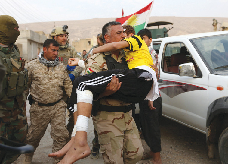 חיילים כורדים ונער פצוע, הלחימה בדאעש. צילום: רויטרס