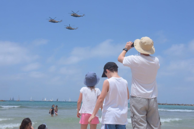 אבא וילדיו מסתכלים על מטס חיל האוויר שעובר מעל חופי תל אביב. צילום: אבשלום ששוני
