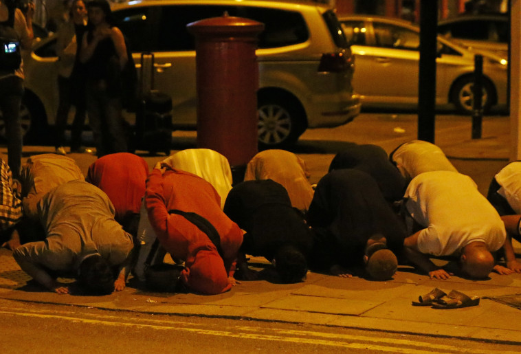 מוסלמים מתפללים לאחר הדריסה. צילום: רויטרס