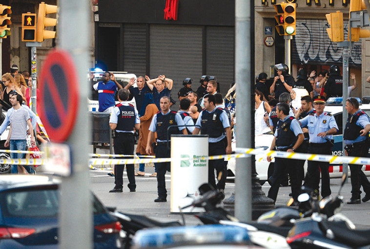 אזרחים מרימים את ידיהם מעל ראשיהם מיד לאחר הפיגוע בברצלונה. צילום: AFP