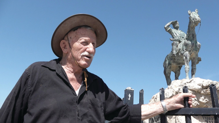 אריק נחמקין על רקע פסלו של אלכסנדר זייד, מתוך הסרט "לצדי רכבת העמק" 