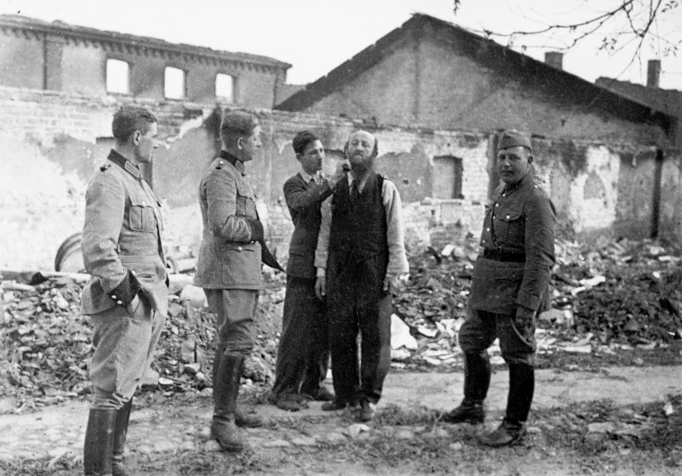 פולני מגלח ליהודי את שערו בפני חיילים גרמנים, 1939. צילום: גטי אימג'ז