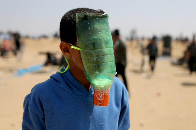 פלסטיני עם מסיכה מאולתרת. צילום: רויטרס