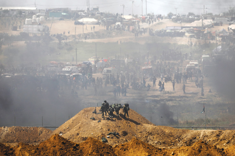 חיילים ישראלים ופלסטינים על הגדר בגבול עזה-ישראל. צילום: רויטרס