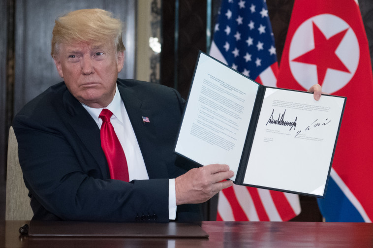 דונלד טראמפ עם ההסכם שנחתם עם קוריאה הצפונית. צילום" AFP