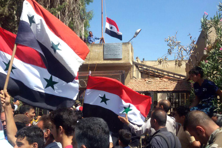 הנפת דגלי סוריה בדרעא (צילום: AFP)
