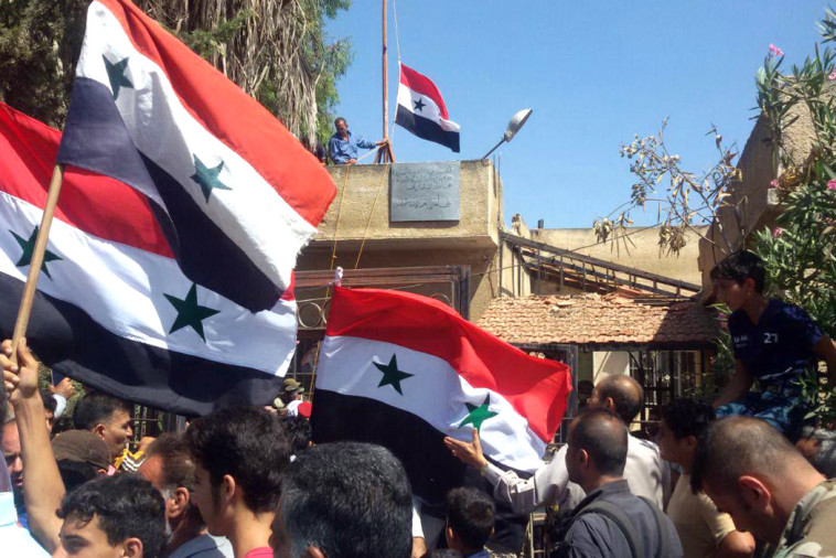 Raising Syrian flags in Daraa (Photo: AFP)