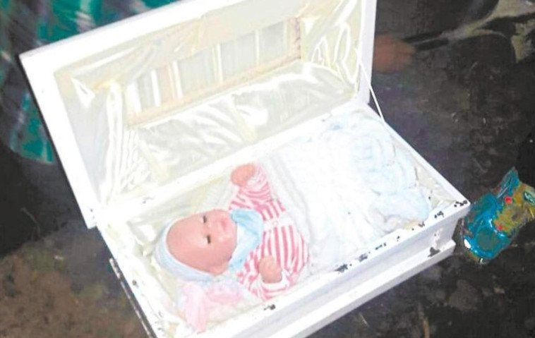 פתחו את הקבר ומצאו בפנים בובת תינוק. צילום מסך