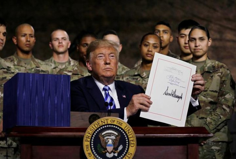טראמפ מציג את חוק ההסמכה לביטחון לאומי לאחר חתימתו. צילום: רויטרס