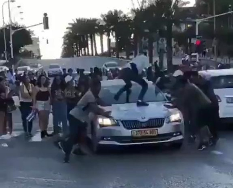 מפגין עומד על רכב נוסע. צילום מסך טוויטר