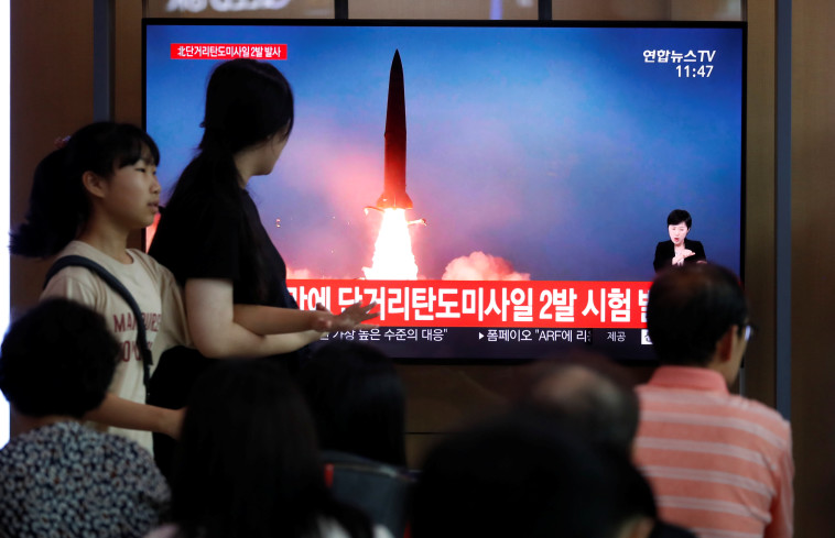אזרחים צופים בניסוי הצבאי בקוריאה הצפונית (צילום: רויטרס)