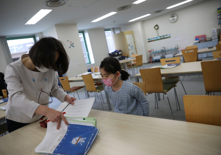נגיף הקורונה: ילדה ומורה עם מסכות ביפן (צילום: רויטרס,STOYAN NENOV)
