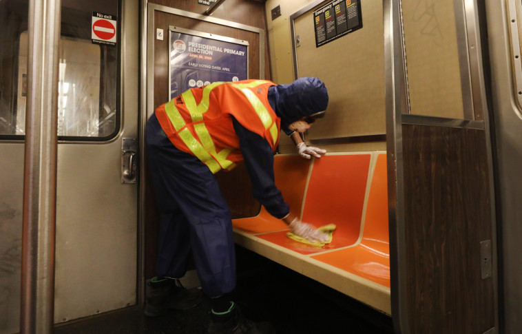 קורונה - גבר מחטא את קרונות הרכבת התחתית בניו יורק