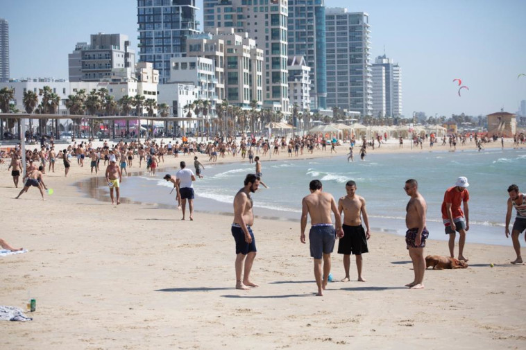 אנשים בחוף הים בת''א. בקרוב יחזור לסגר?