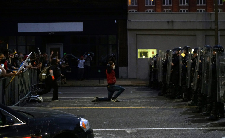 מפגין בארה''ב כורע ברך מול שוטרים (צילום: רויטרס)