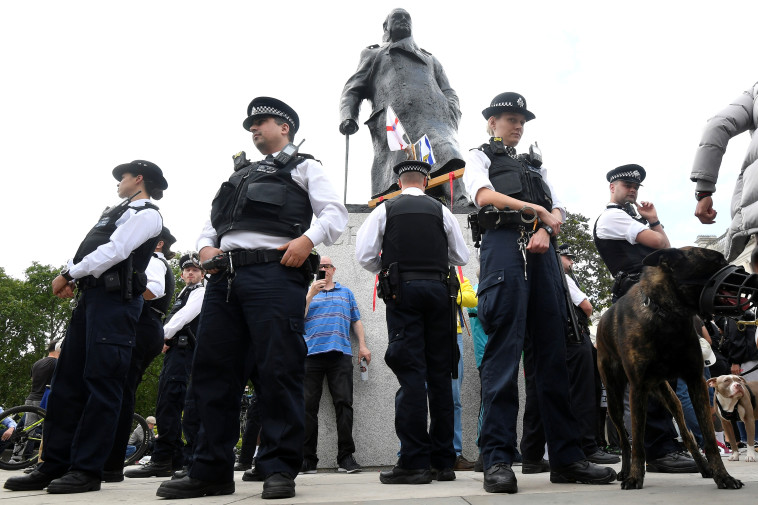 שוטרים מגנים על פסלו של וינסטון צ'רצ'יל במהלך המחאה (צילום:  REUTERS/Toby Melville)