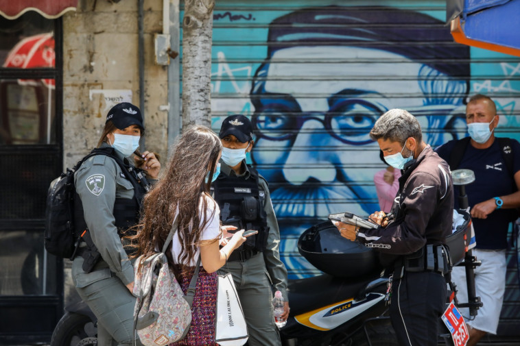 שוטרים אוכפים את הנחיות ההתקהלות לנגיף הקורונה
