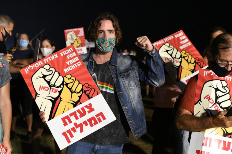 מפגינים עם שלטי צעדת המיליון בגן צ'ארלס קלור בת''א