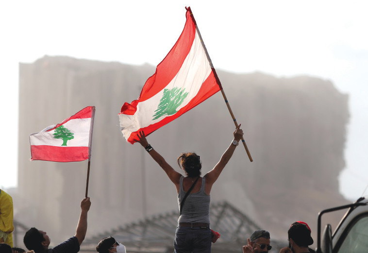 תושבי ביירות ברקע הריסות הנמל לאחר הפיצוץ