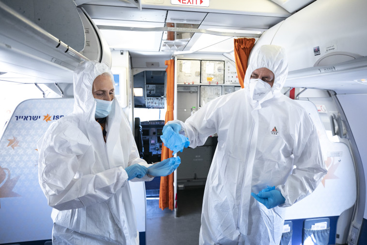 קורונה - דיילים לובשים בגדי הגנה במהלך טיסה לאילת