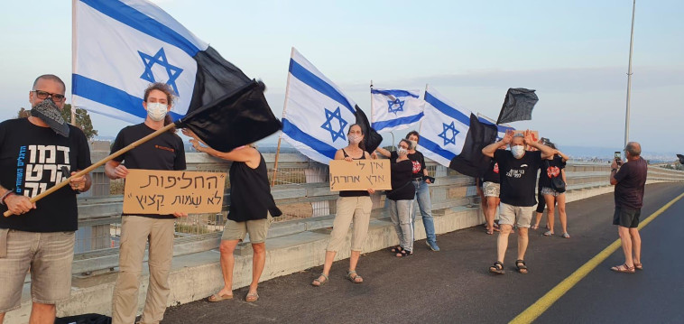 הדגלים השחורים מניפים שלטים (צילום: אריק בנדר)