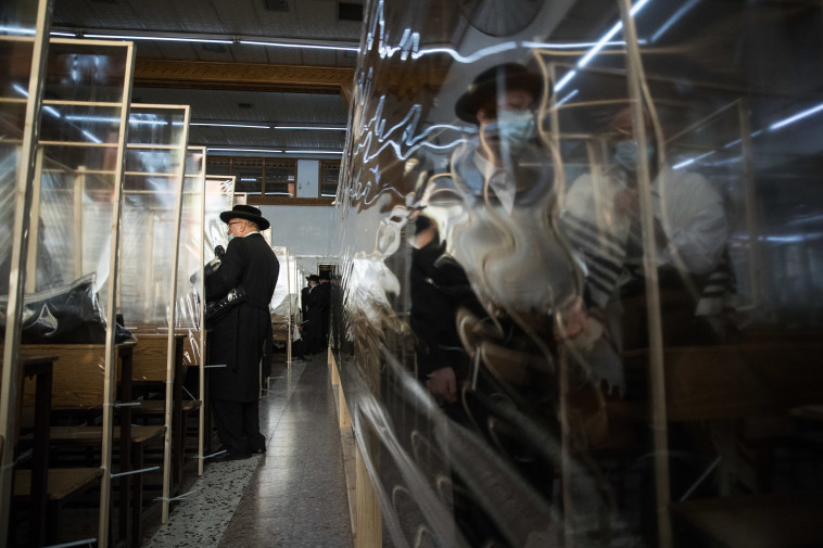 קורונה - מחיצות בין מתפללים בבית כנסת במאה שערים (למצולמים אין קשר לנאמר בכתבה)