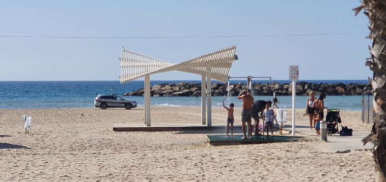 ניידת משטרה לצד מתרחצים בחוף הים