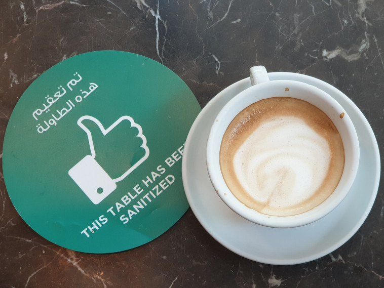 שולחן בבית קפה בדובאי עם הודעה על החיטוי. הקפדה בפרטים הקטנים 