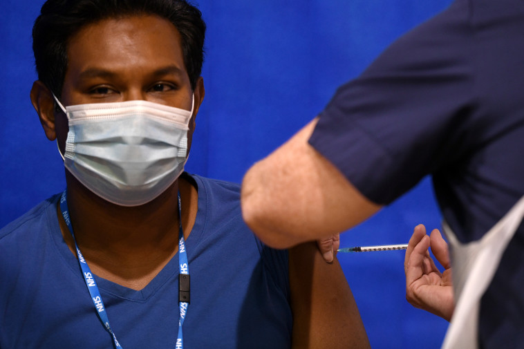 גבר מקבל את חיסון פייזר בבריטניה