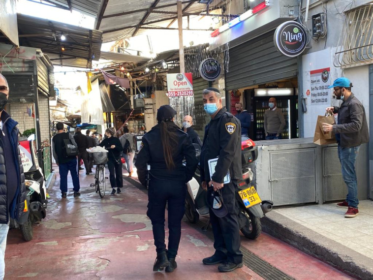 שוטרים אוכפים את הסגר בשוק הכרמל בתל אביב (צילום: אבשלום ששוני)