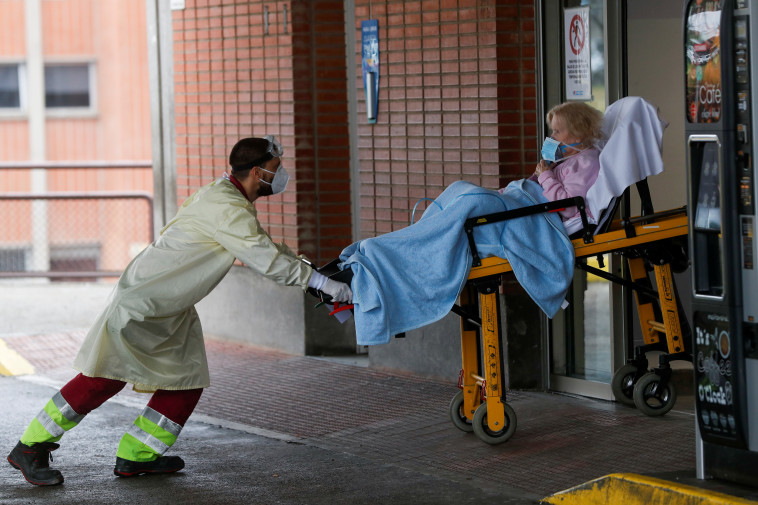 איש צוות רפואי מכניס מטופלת למחלקת טיפול נמרץ בלגאנס, ספרד (צילום: REUTERS/Susana Vera)