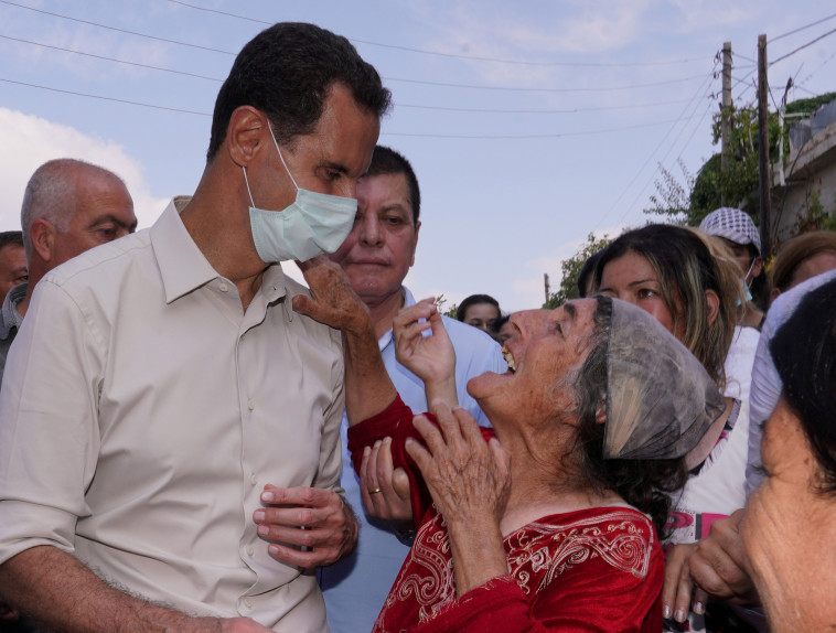 אסד עם תושבים סורים (צילום: SANA/Handout via REUTERS)