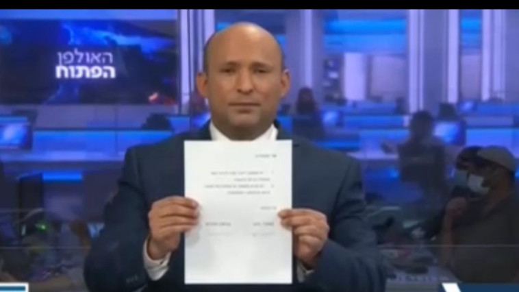 Bennett signs the document on Channel 20 (Photo: Channel 20 screenshot)