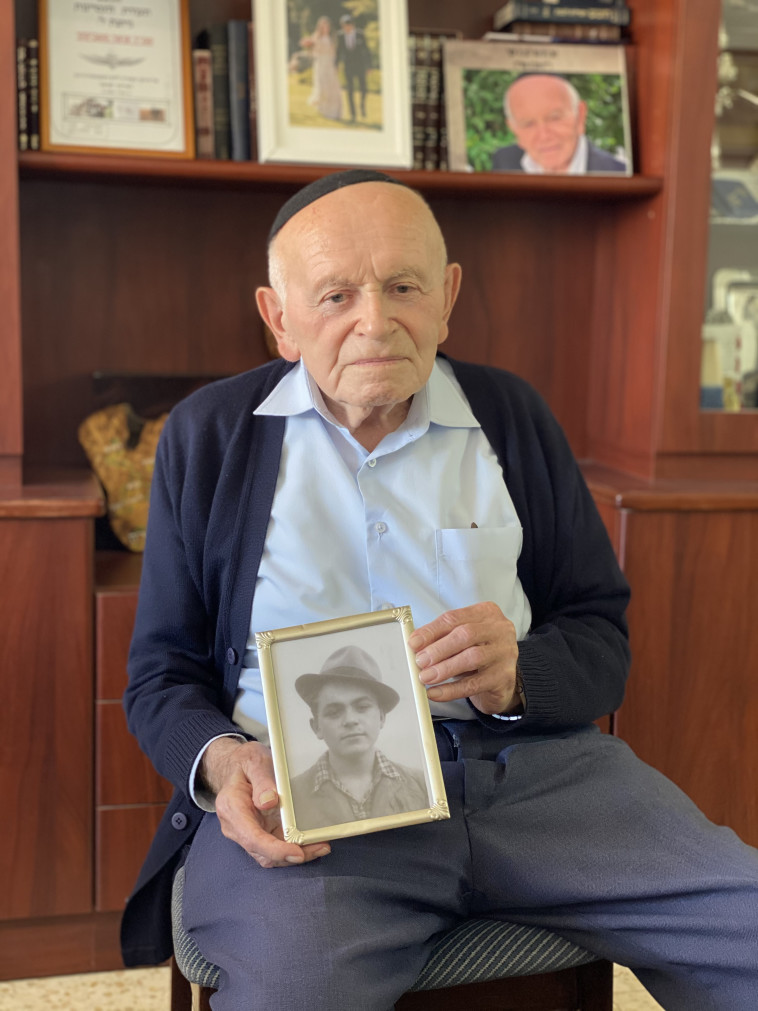 קליינמן מחזיק את תמונתו כנער צעיר