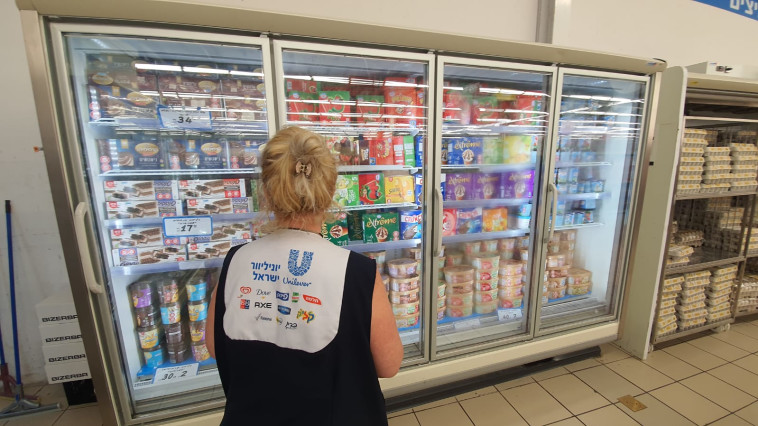 עובדת יונילוור מול מקרר הגלידות בסופר