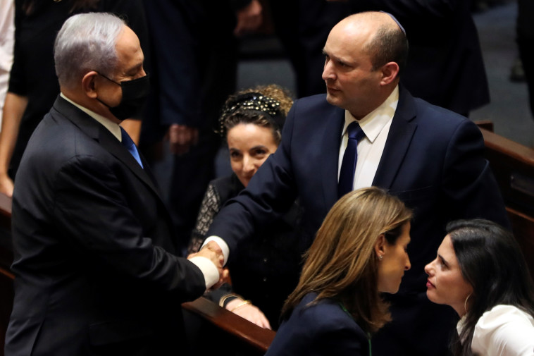 Benjamin Netanyahu serre la main de Naftali Bennett après l'approbation du gouvernement à la Knesset (Photo : REUTERS/Ronen Zvulun)