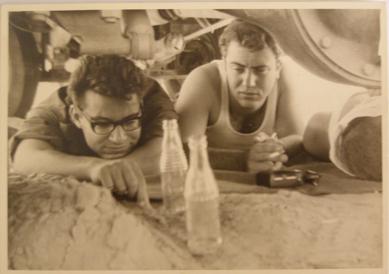 אברהם זיגמן ולואי להב שוכבים ליד התעלה מתחת משאית הצוות בשעת התקפת מיגים מצריים (צילום: פרטי)