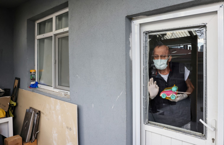 מוזאפר פוגש את משפחתו רק מבעד לחלון (צילום: רויטרס)