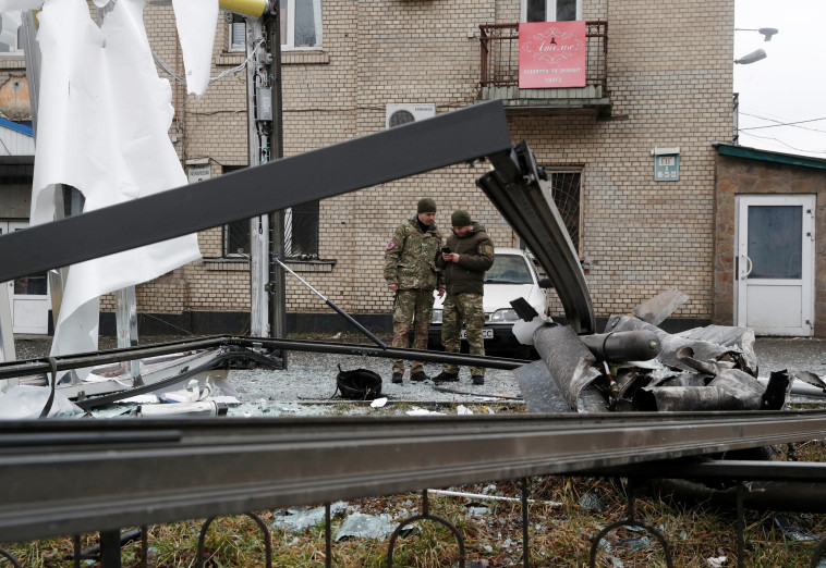 שוטרים אוקראינים עומדים סמוך לשרידי טיל רוסי שנפל בקייב (צילום: REUTERS/Valentyn Ogirenko)