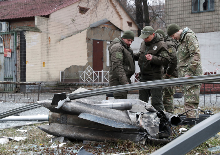 שוטרים אוקראינים עומדים סמוך לשרידי טיל רוסי שנפל בקייב (צילום: REUTERS/Valentyn Ogirenko)