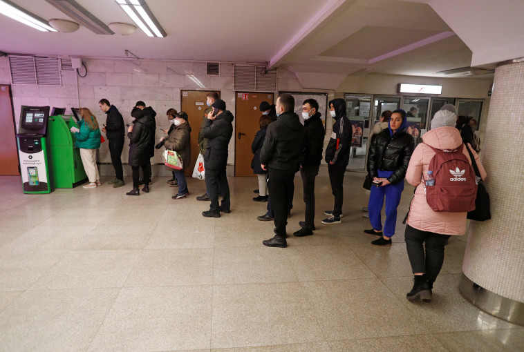 תושבי אוקראינה ממתינים סמוך לכספומט במטרה להוציא כסף לאחר הצהרת פוטין (צילום: REUTERS/Valentyn Ogirenko)