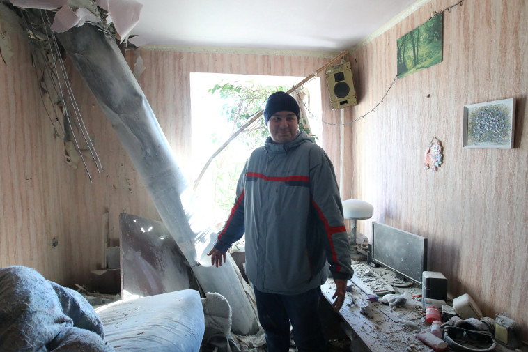 תושב חרקיב בהריסות בביתו לאחר הפצצה של צבא רוסיה